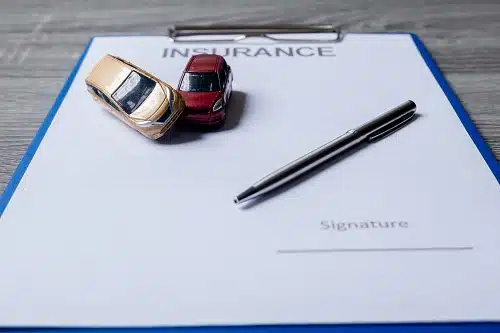 Car and pen on car insurance excess documents. 