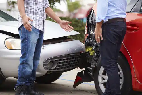 two men trying to find consensus over a car accident they've just had 