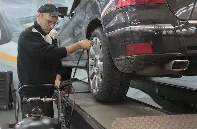 mechanic checks car tyre pressure