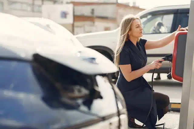 A woman unplugs her zero emissions vehicle as she gets ready to head out to work for the day