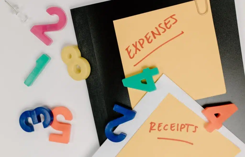 The busy desk of a person who is doing paperwork for claiming car expenses for business purposes