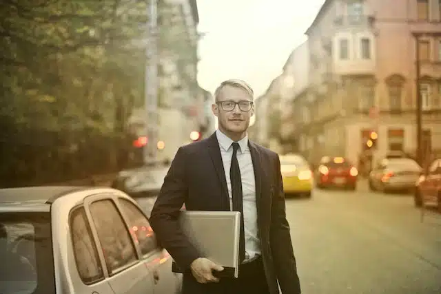 a freelancer has just parked his car and is heading to a meeting with his laptop