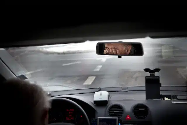 Tired driver rubbing his eyes driver fatigue road