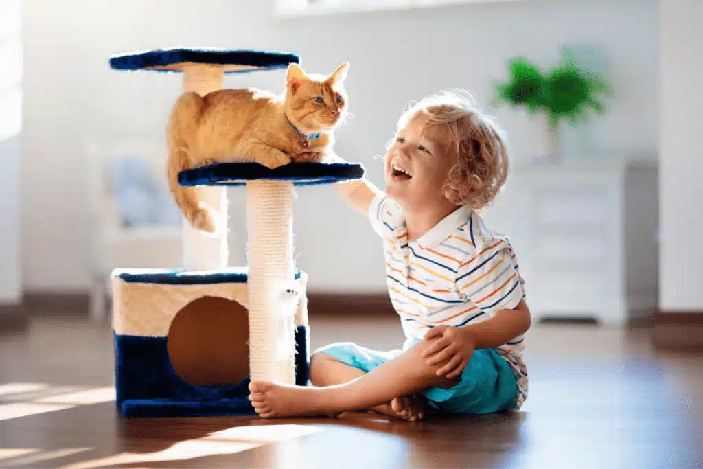 small child sitting on floor next to ginger cat knows he has one of the best pets for kids