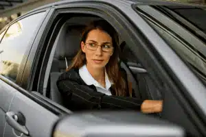 women behind the wheel mentally tallies business car expenses she needs to claim for