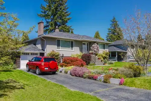 red car parked outside home on driveway