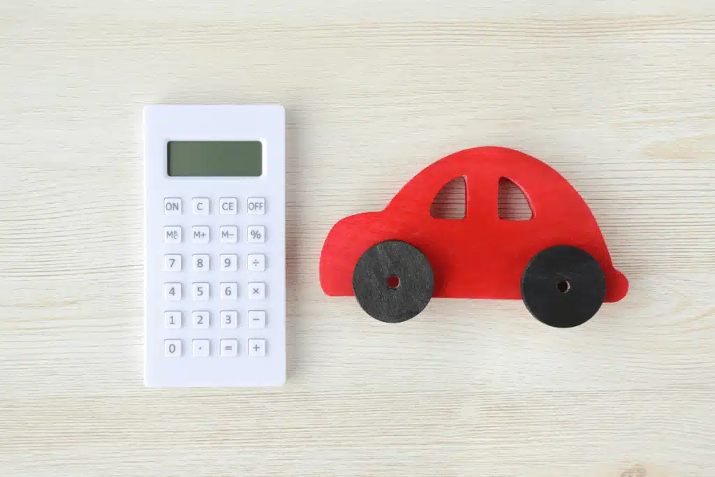 Image of red toy car next to calculator. Doing the maths properly is important for deciding if a novated lease or car loan is right for you