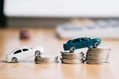 image of toy cars on top of three piles of coins indicating the savings needed to apply for car loans and leases