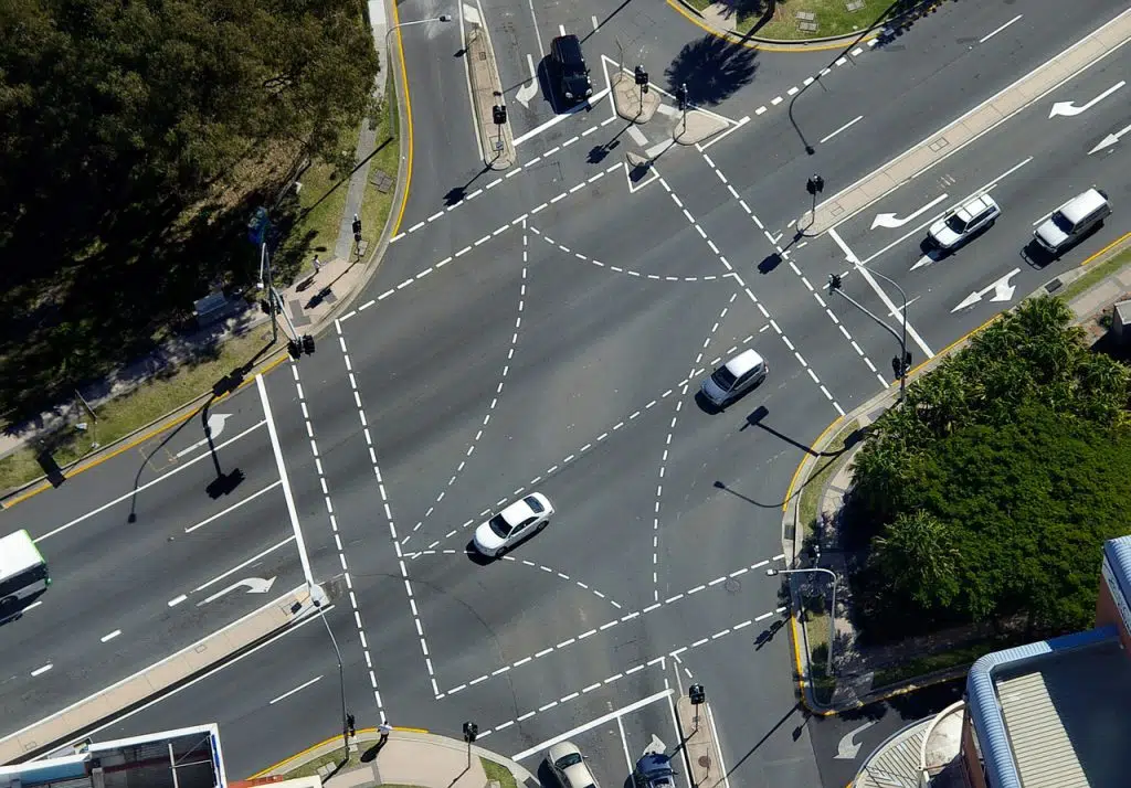 cars at an intersection - mostly white cars, which is the safest car colour