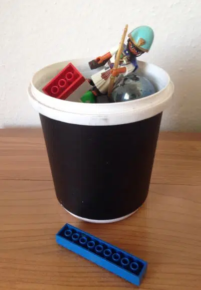 A used 2 liter yoghurt tub and lid are great for keeping small toys organised in your car.