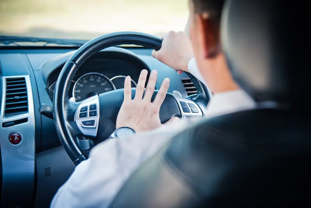 man in car hooting dealing with someone else's road rage