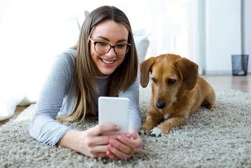 woman and her pet dog looking at technology smartphone app