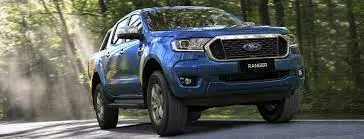 the ford ranger is one of australia's most popular towing cars and is also is quite a fuel efficient car. This is a blue ford ranger driving in a forest 