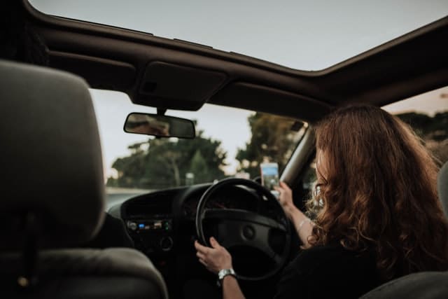 car insurance for young drivers is more expensive because some young drivers like this woman drive and text