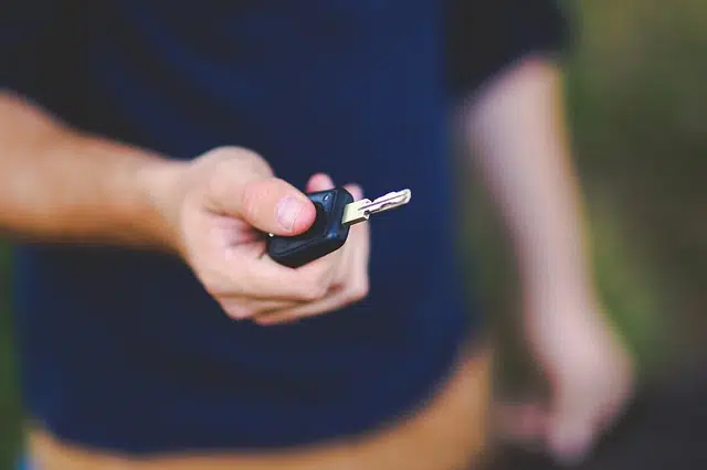 close up of man's hand holding used car keys