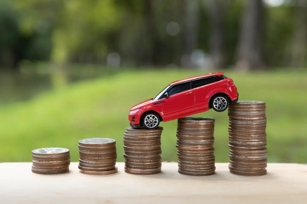 how to budget for a car image of toy car on coins indicating car budget