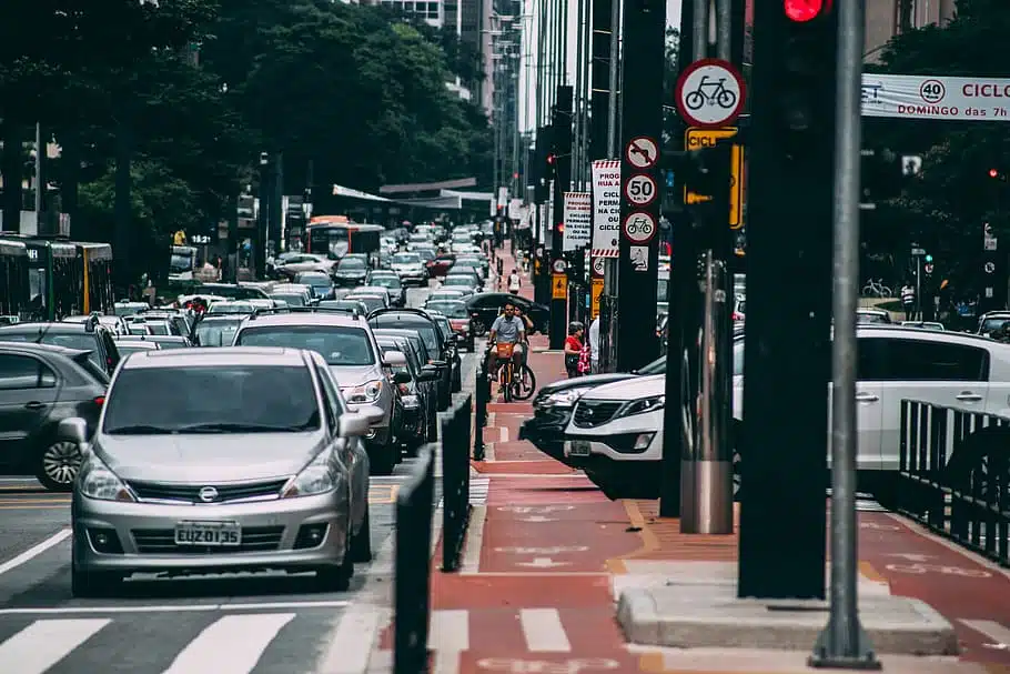 A city street with a lot of cars equipped with car safety features on it.