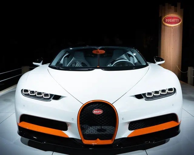 luxury cars at car show - white bugatti parked under lights