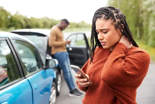 female driver after crash finding out about her car insurance on phone