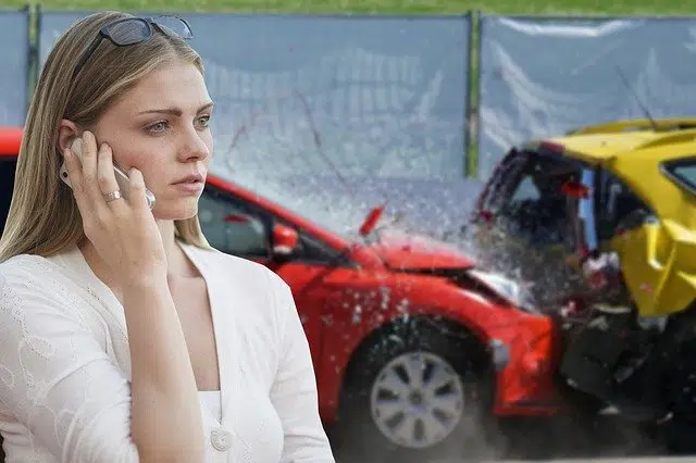 woman on phone after car crash driving without insurance