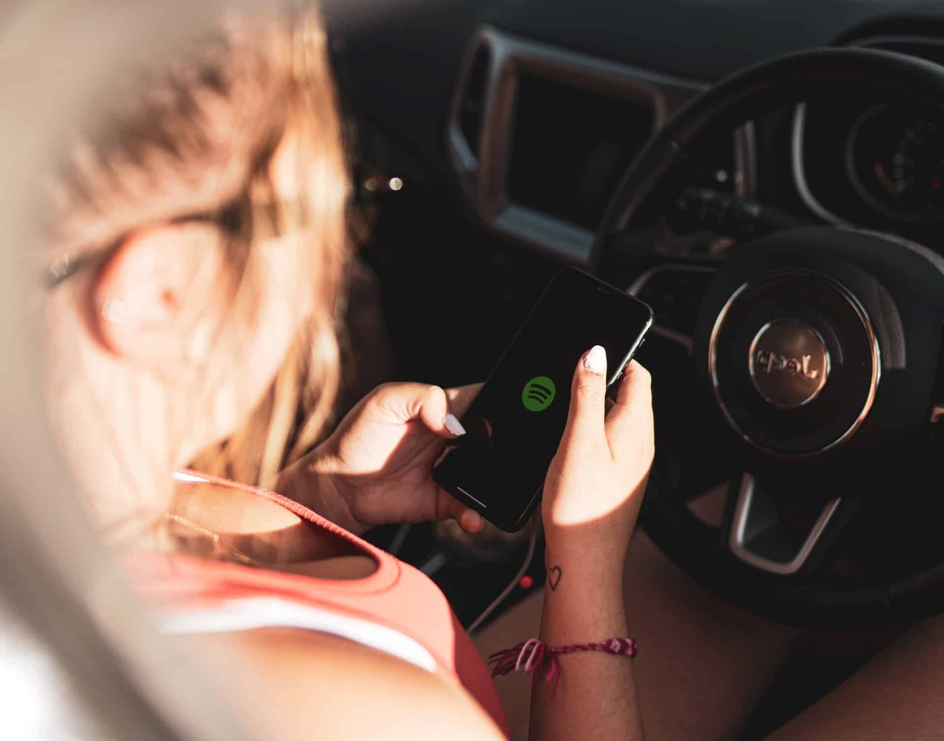 woman opens spotify behind the wheel and is guilty of distracted driving