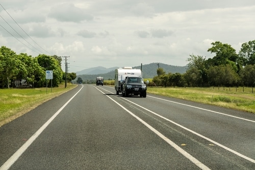 black diesel 4x4 car towing caravan on highway in Australia in Queensland