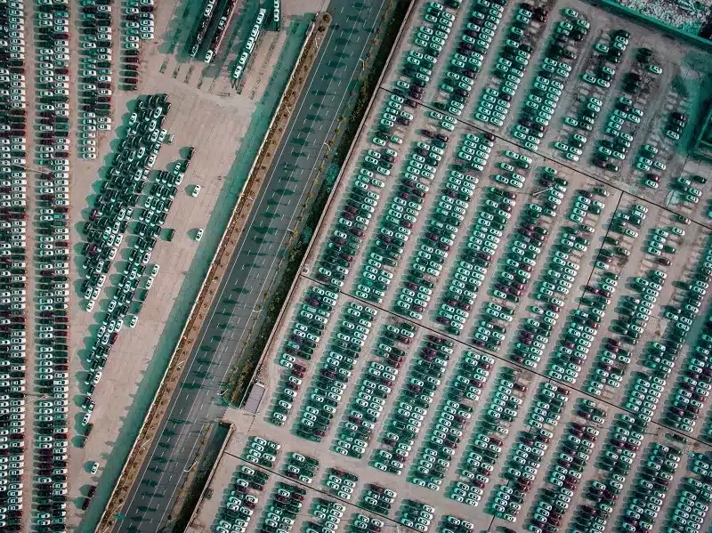 An aerial view of a parking lot crowded with cars.