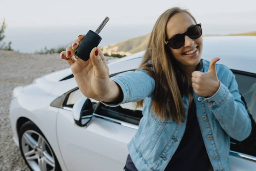 woman with new car keys in hand after new for old car insurance replacement from total loss