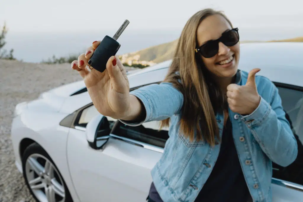 woman with new car keys in hand after buying cars at auction 