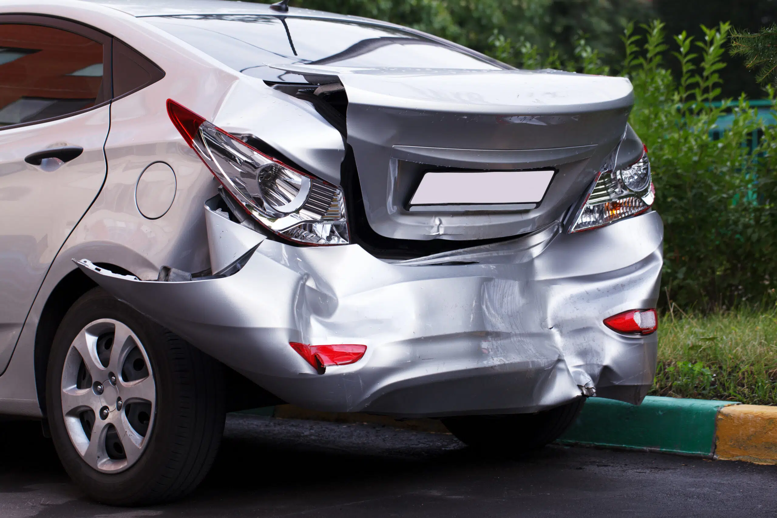 back of silver new car crushed in car accident - a new car like this might be covered for replacement under new for old car insurance