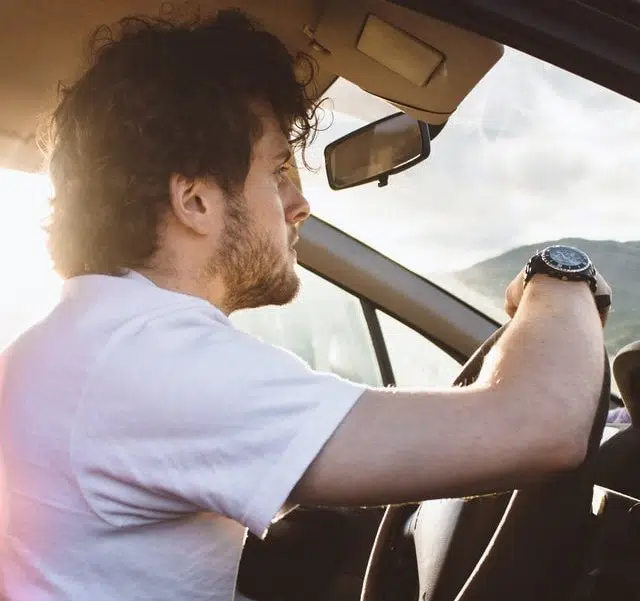 young man leaning on steering wheel inside car