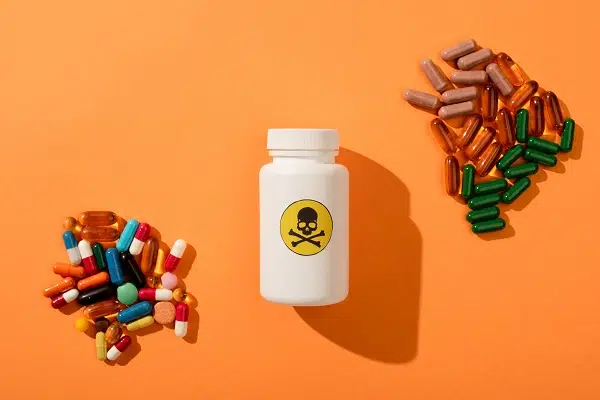 Top View of Container With Dangerous Poison And Dietary Supplements on Orange Background.