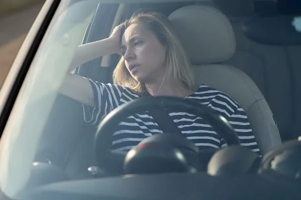 Annoyed tired female sit on driver seat in car frustrated with heavy traffic jams. 