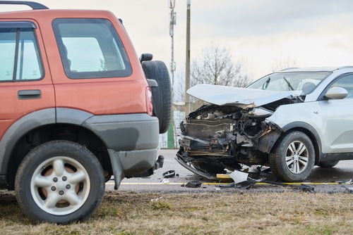 car crash with red 4x4 and white car. If you crash your car with an expired drivers licence you insurer might not cover your claim