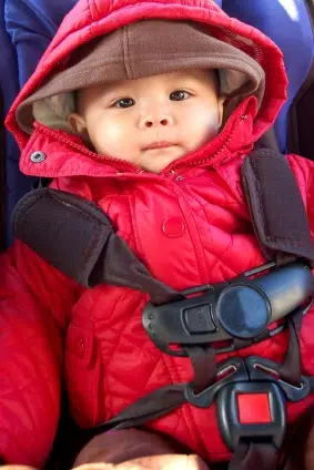 A baby in a car seat that is being used wrong