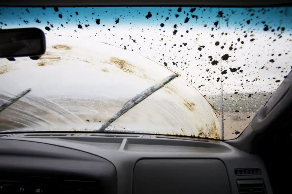 A windshield splattered with mud. Though there's no such thing as a dirty car fine, you can get fined for a dirty number plate - so be careful!