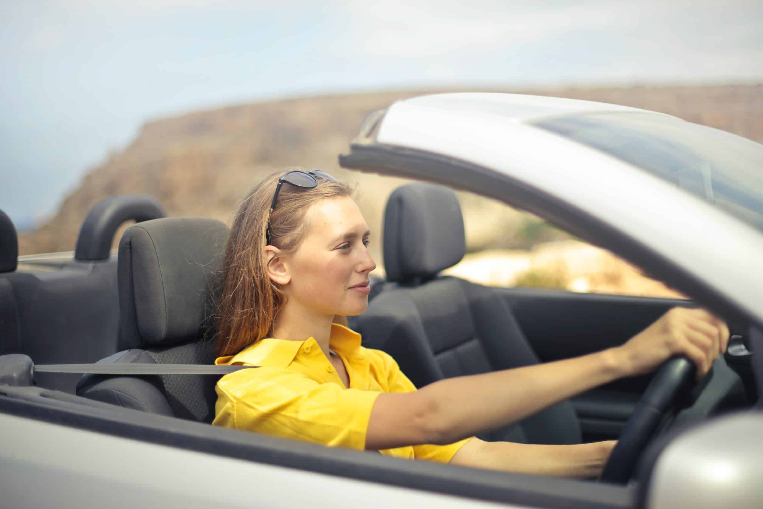 This female driver in a yellow top considers tips to prepare for her driving test in Australia.