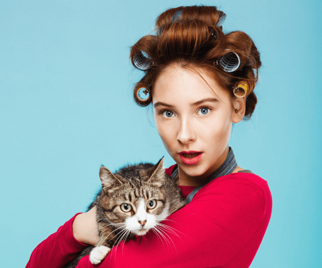 a woman with curlers holding a cat. the crazy cat lady stereotype endures in 2023