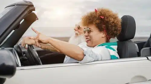 Happy senior couple having fun in convertible car during summer vacation 