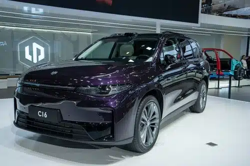 A dark purple electric SUV, model C16, is displayed at an auto show, showcasing the latest advancements that highlight the ongoing debate of electric vs petrol cars in 2023.