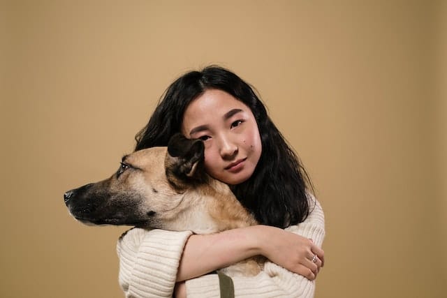 A woman hugs her dog. Adopting a rescue dog can be rewarding and challenging