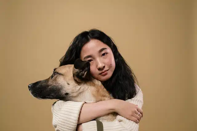 A woman hugs her dog. Adopting a rescue dog can be rewarding and challenging