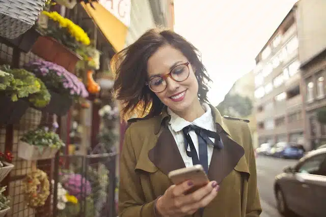 woman transfers payment for an end of financial year car sales purchase and smiles at the thought of buying a car