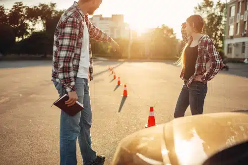 Male instructor and woman student on lesson for novice car drivers, driving school concept.