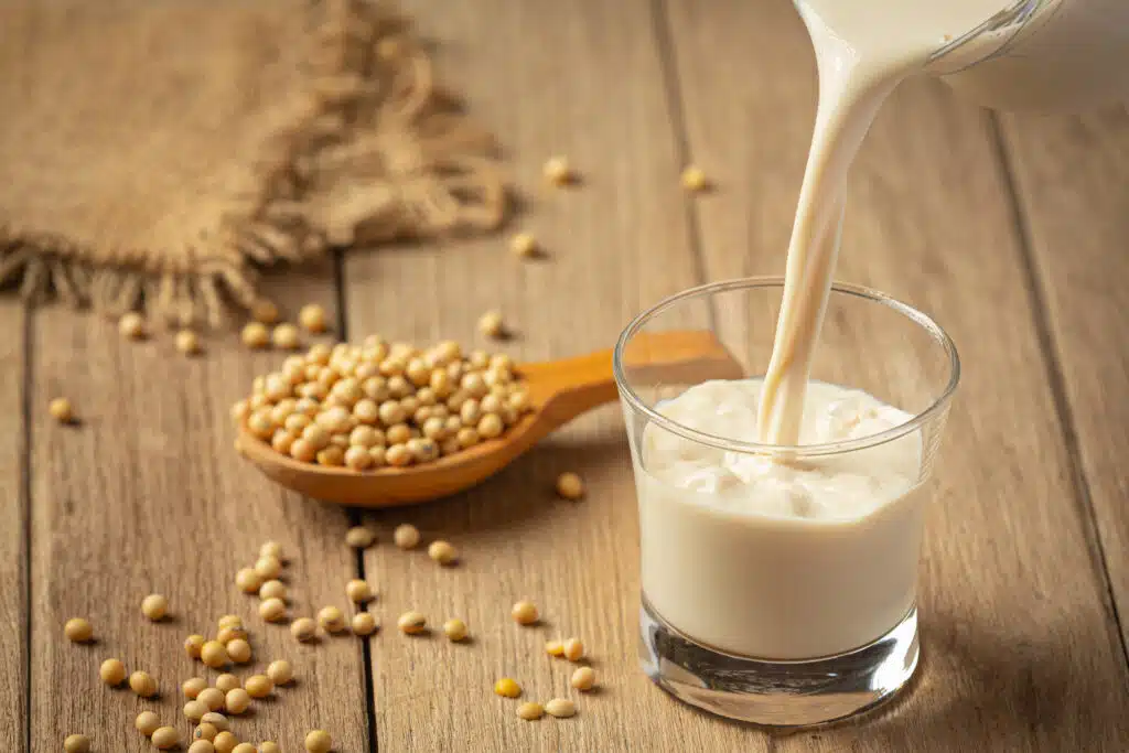 A clear glass filled to the brim with chilled, creamy soy milk. Cats are lactose intolerant so they require specially formulated milk.