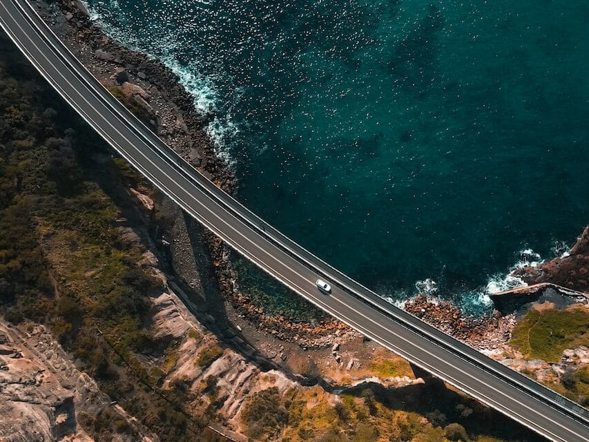 cars drive along an ocean highway in Australia