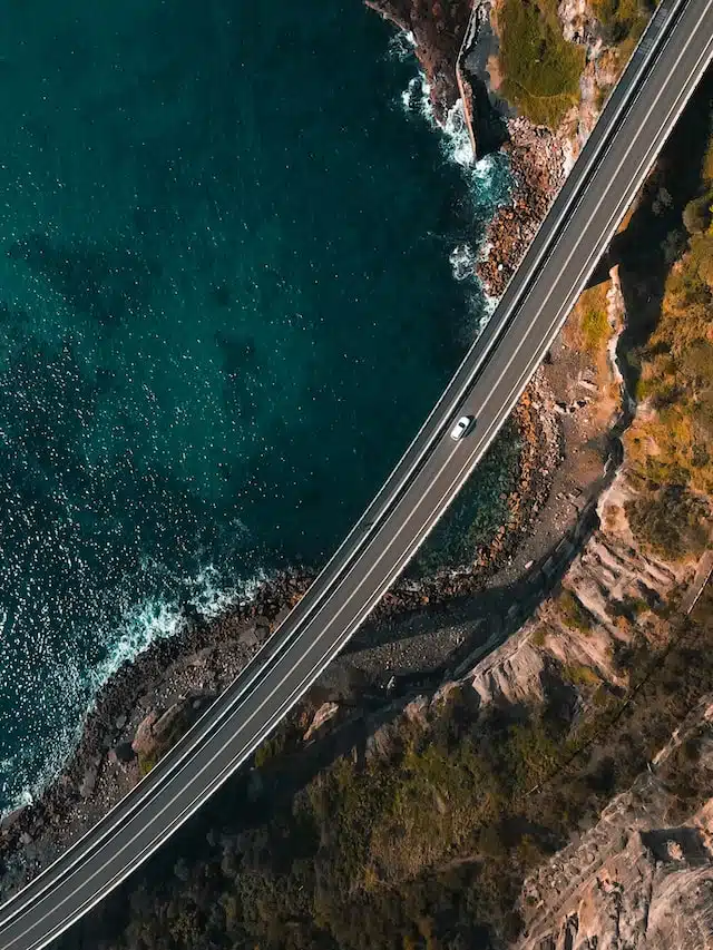 cars drive along an ocean highway in Australia