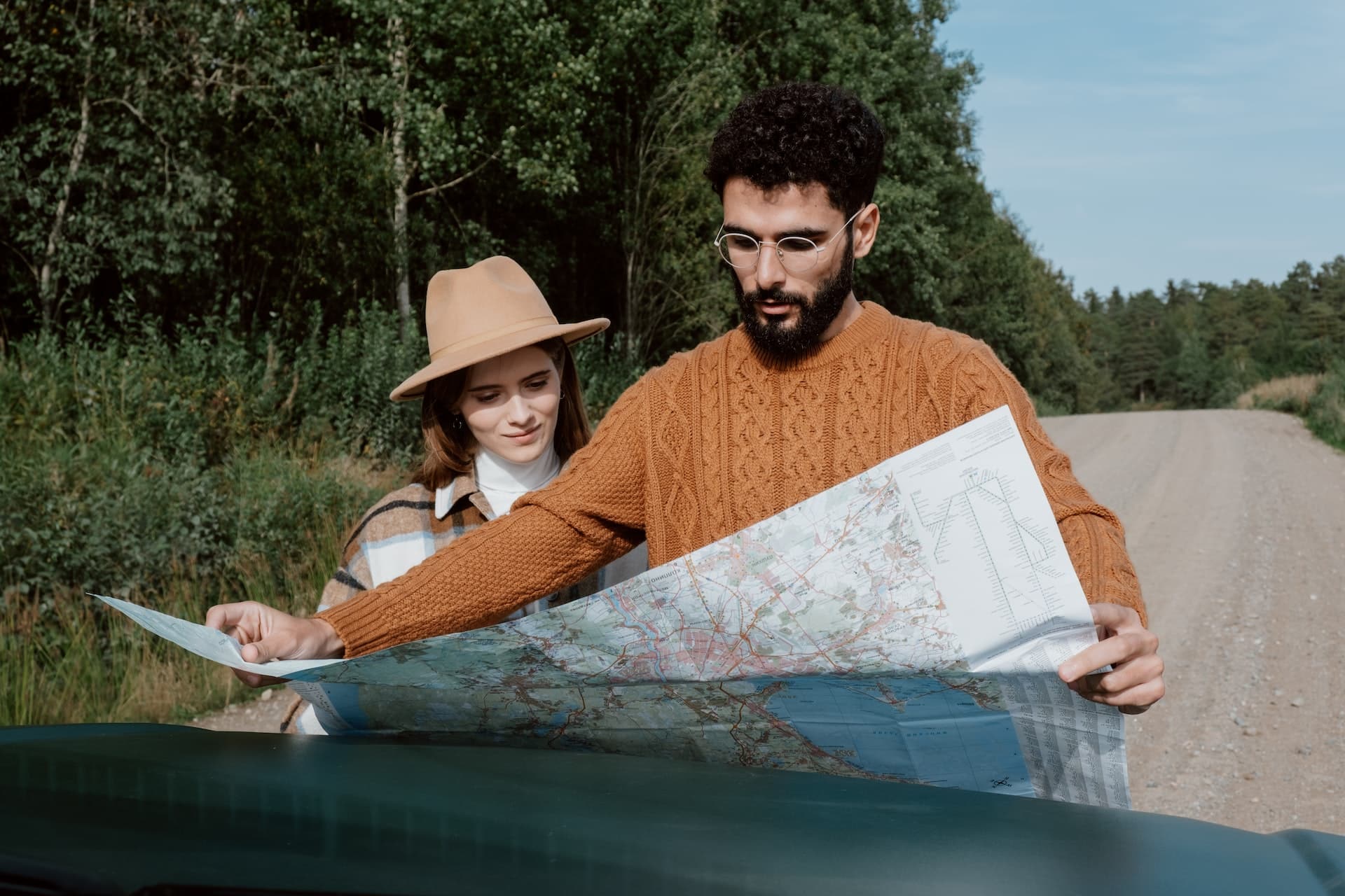 On their holiday road trip, this couple looks at a map for directions.