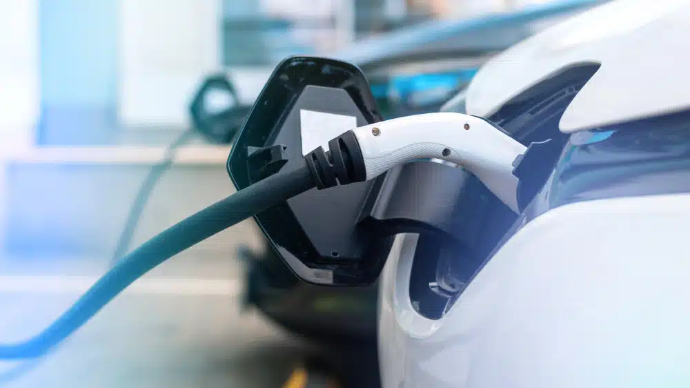 This image shows someone charging an electric car. the owner may be shopping for insurance for a tesla.