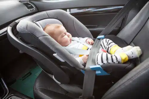 A baby in a car seat that's being used wrong.